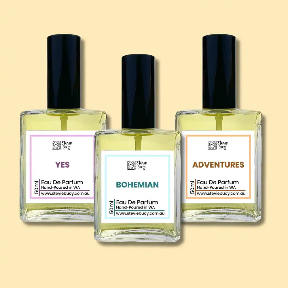 Three bottles of perfume with labels reading ’Yes,’ ’Bohemian,’ and ’Adventures.’