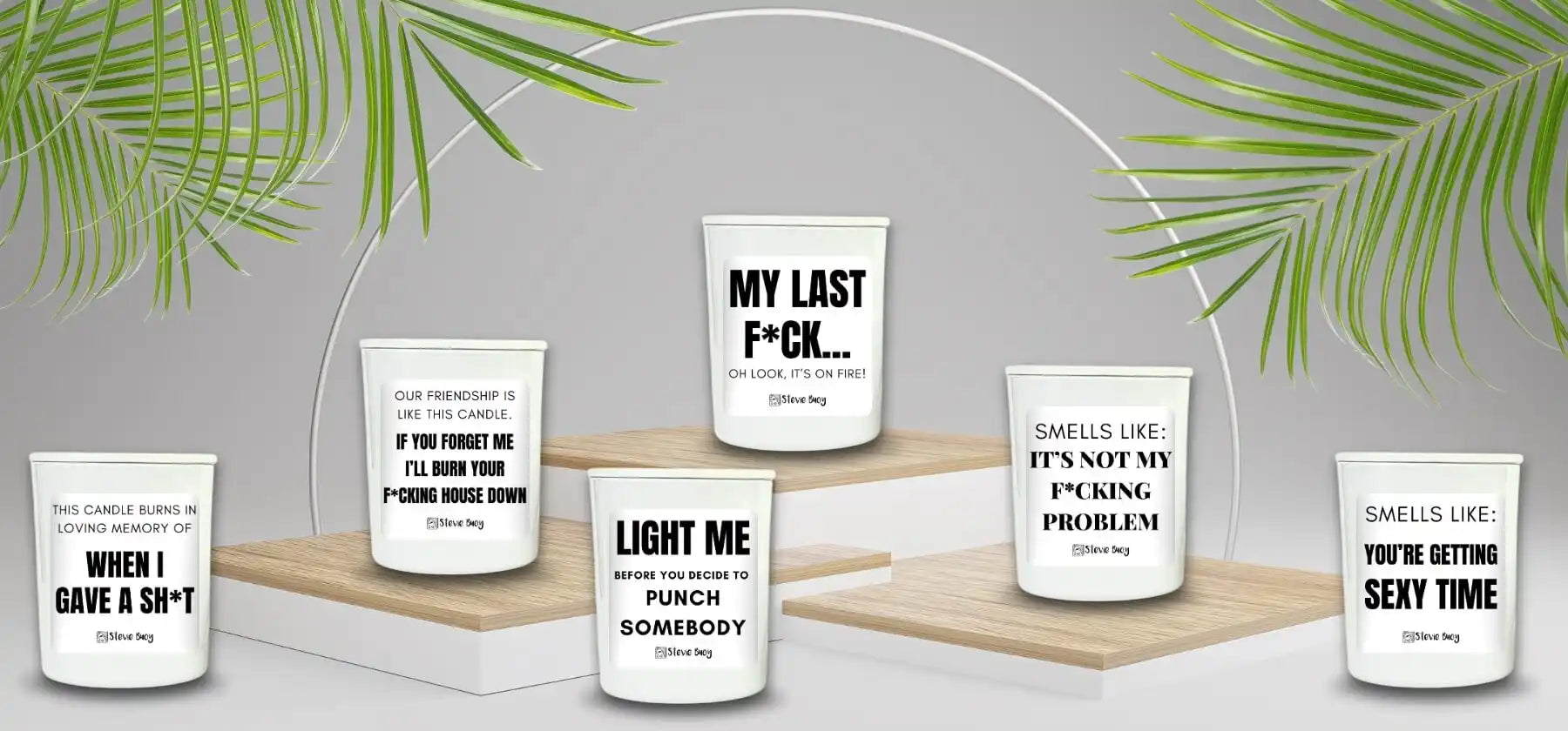 White candles with humorous text messages displayed on glass holders arranged on wooden platforms.